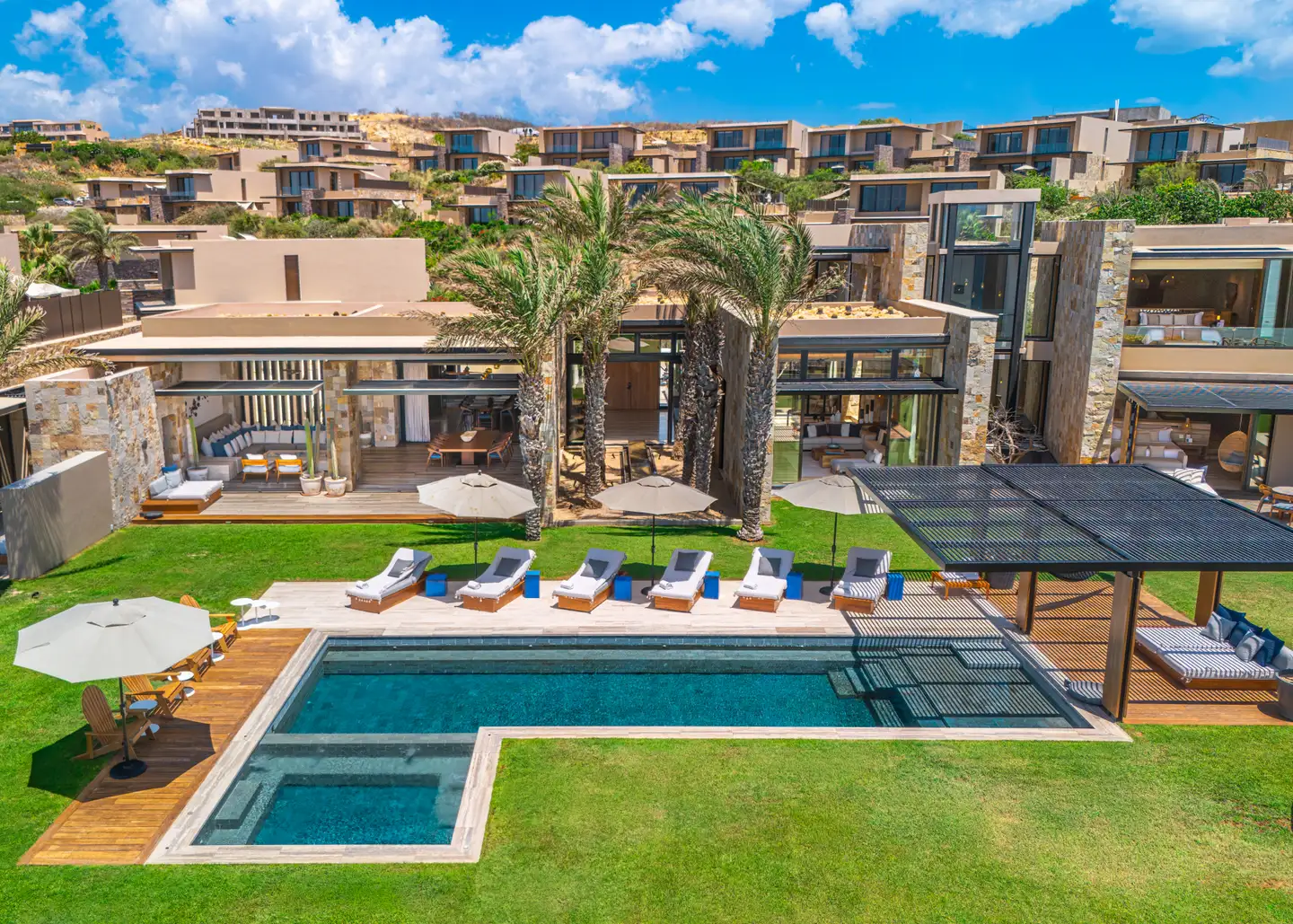 Aerial view of a Grand Reserve residence's pool terrace and motor court, framed by mature palms.