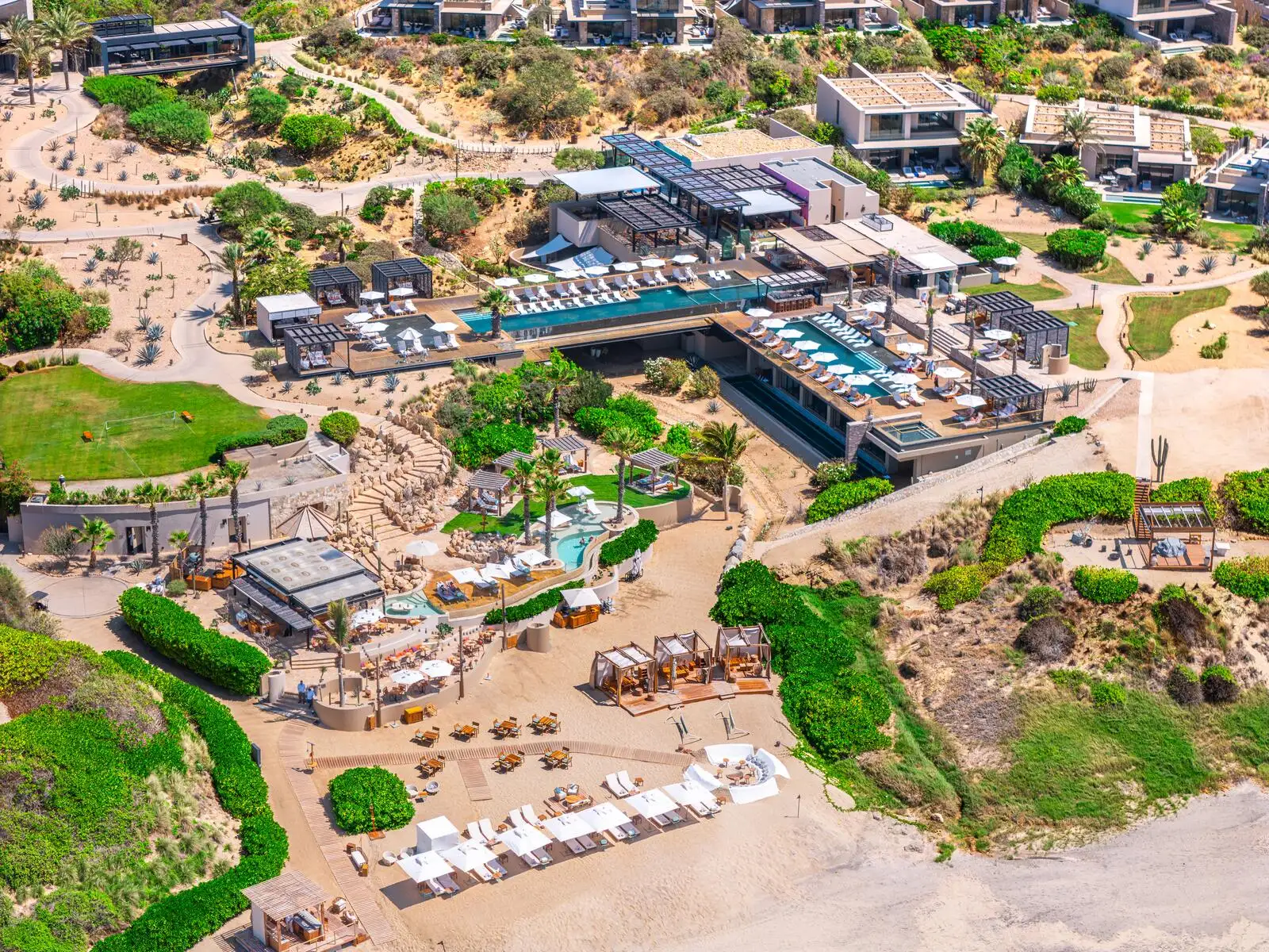 Aerial view of Zadún's pool and beach-club terrace, cabanas and sun loungers framing an infinity-edge lap pool above a private beach.